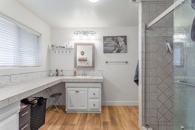 bathroom featuring vanity, a shower with shower door, and wood-type flooring