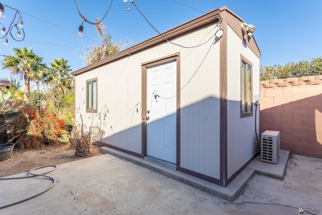 exterior space with ac unit and an outbuilding