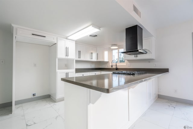 187 S San Clemente Dr, Yuma, AZ 85364 - kitchen featuring island range hood, light marble finish flooring, baseboards, a peninsula, and white cabinets