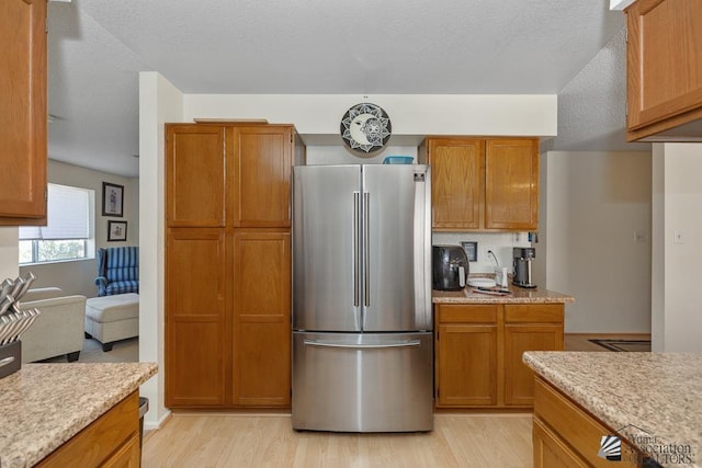 7442 E 24th Ln, Yuma, AZ 85365 - kitchen featuring freestanding refrigerator, light wood finished floors, and brown cabinetry