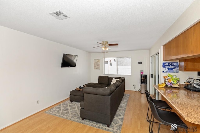 7442 E 24th Ln, Yuma, AZ 85365 - living area featuring light wood-type flooring, ceiling fan, a textured ceiling, and a desk