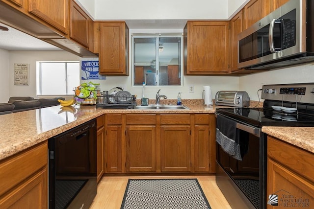 7442 E 24th Ln, Yuma, AZ 85365 - kitchen with appliances with stainless steel finishes, a sink, light wood-type flooring, and brown cabinets