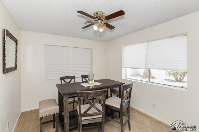 7442 E 24th Ln, Yuma, AZ 85365 - dining room with light colored carpet, ceiling fan, and baseboards