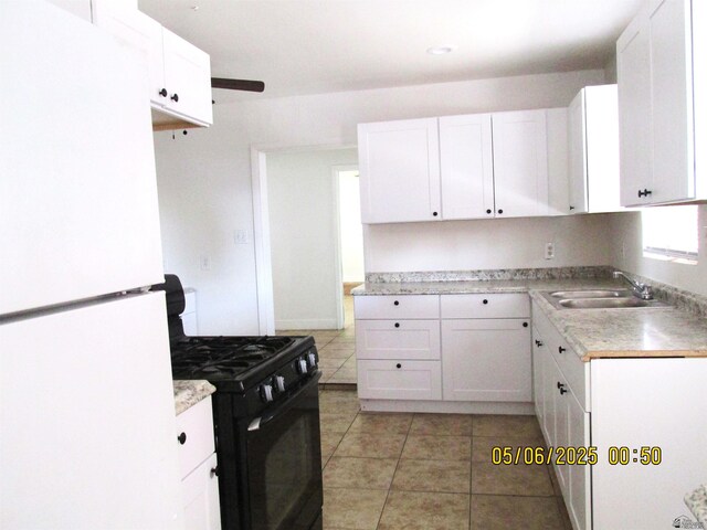 1429 S 12th Dr, Yuma, AZ 85364 - kitchen with freestanding refrigerator, black range with gas cooktop, a sink, light tile patterned floors, and light countertops