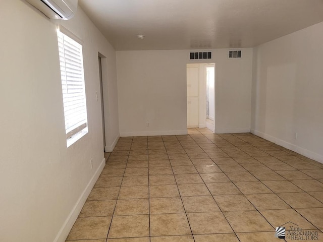 1429 S 12th Dr, Yuma, AZ 85364 - empty room featuring a wall mounted AC, light tile patterned flooring, and baseboards