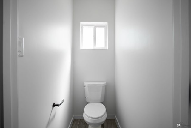 bathroom with baseboards and toilet