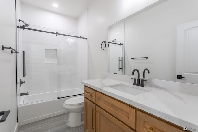 full bath with vanity, wood finished floors, toilet, recessed lighting, and enclosed tub / shower combo