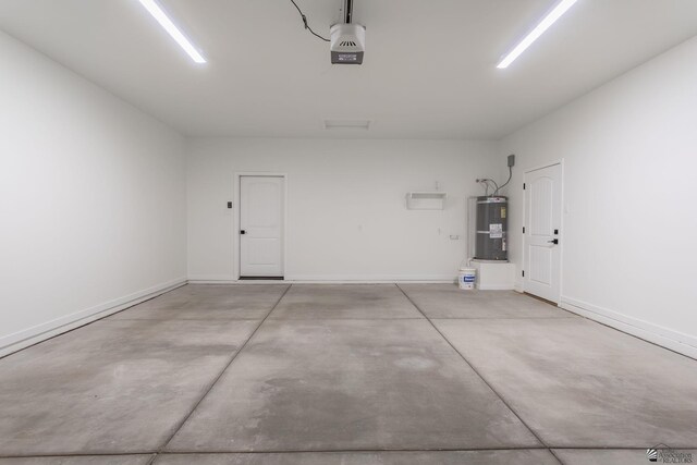 garage featuring baseboards, strapped water heater, and a garage door opener