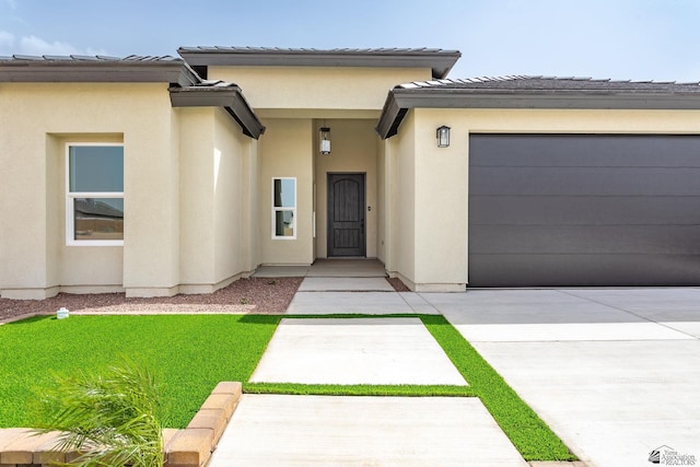 view of front of house featuring a garage, driveway, and stucco siding