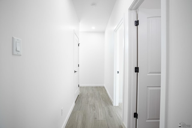 hallway featuring recessed lighting and baseboards