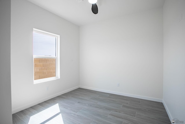 empty room with baseboards, a ceiling fan, and wood finished floors