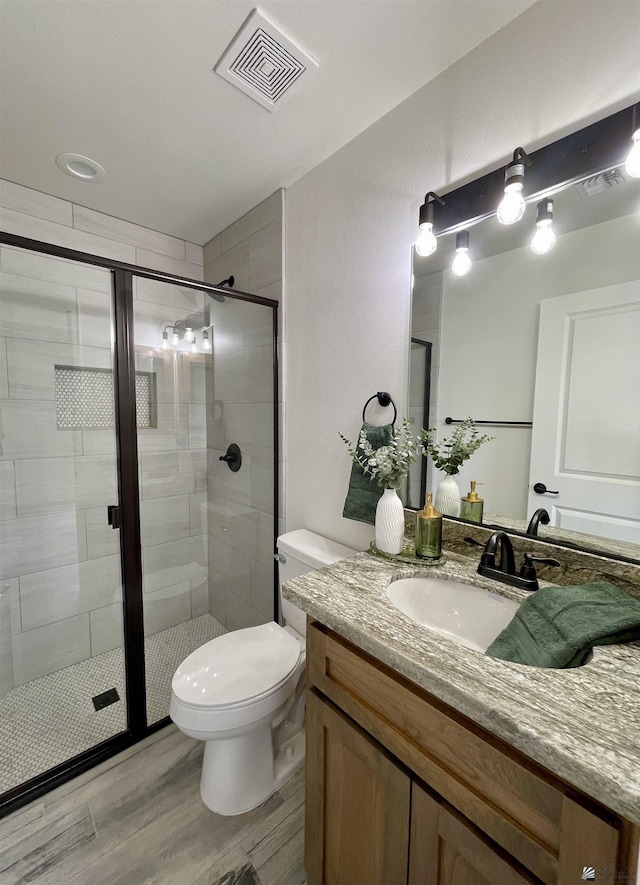 369 S 7th Ave, Yuma, AZ 85364 - bathroom featuring a stall shower, toilet, vanity, and wood finished floors