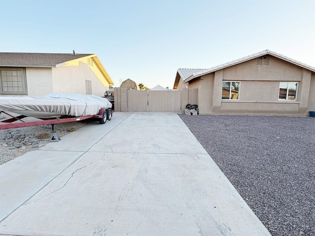 11451 E 27th Pl, Yuma, AZ 85367 - view of property exterior with fence, a gate, stucco siding, and concrete driveway