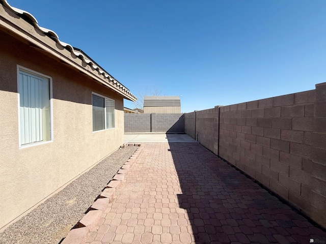 11451 E 27th Pl, Yuma, AZ 85367 - view of side of home featuring a fenced backyard, stucco siding, and a patio area