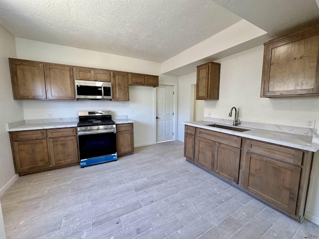 221 E Spring St, Somerton, AZ 85350 - kitchen with stainless steel appliances, a sink, a textured ceiling, and light countertops