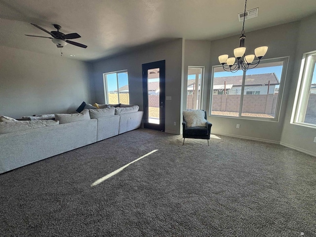 living room with a healthy amount of sunlight, carpet flooring, ceiling fan with notable chandelier, and visible vents