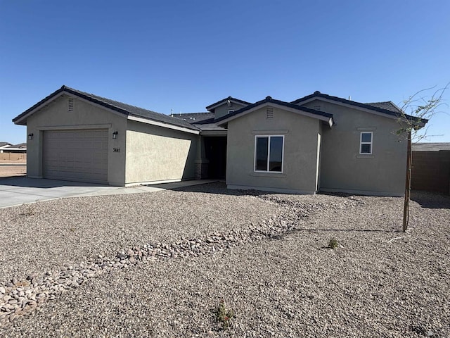 ranch-style house featuring a garage, stucco siding, and driveway