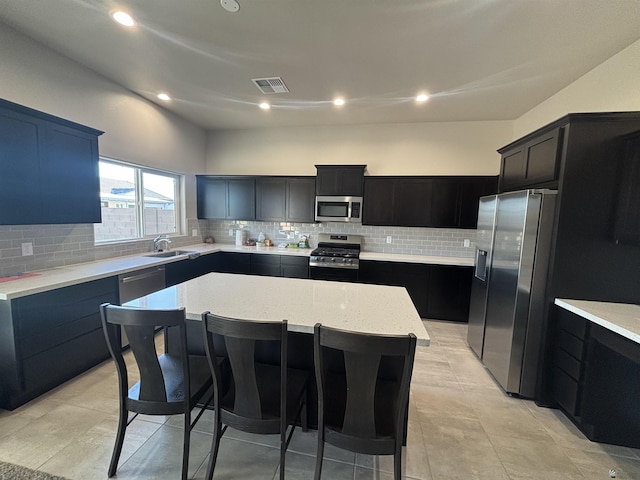 kitchen featuring a center island, backsplash, stainless steel appliances, and visible vents