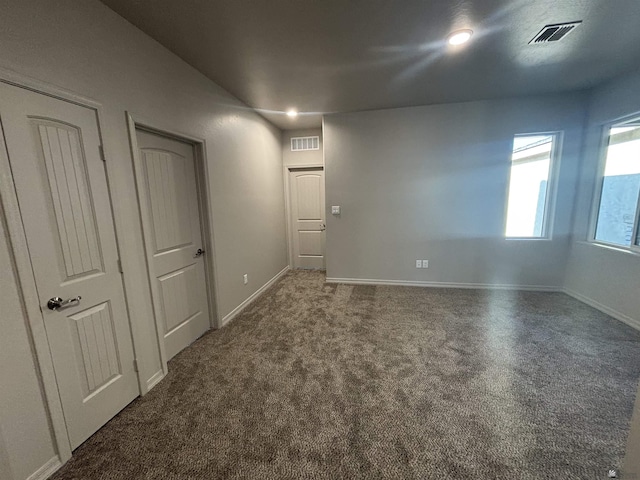 spare room with baseboards, visible vents, and carpet