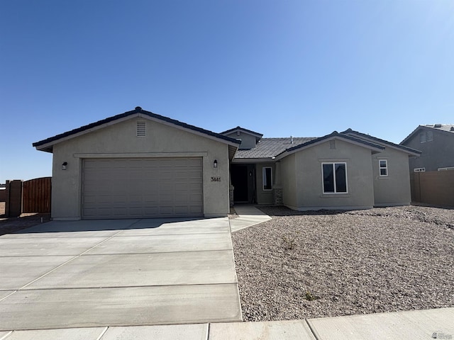 single story home with concrete driveway, an attached garage, fence, and stucco siding