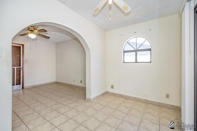 12344 E Calle Maria, Yuma, AZ 85367 - spare room with arched walkways, ceiling fan, light tile patterned floors, and a textured ceiling