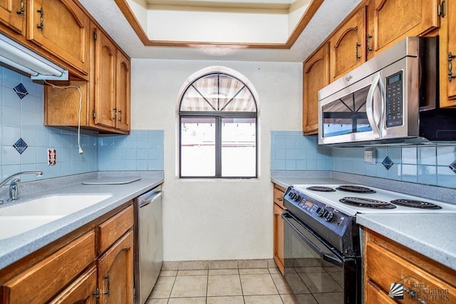 12344 E Calle Maria, Yuma, AZ 85367 - kitchen with brown cabinets, stainless steel appliances, light tile patterned flooring, and light countertops