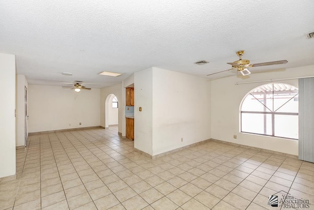 12344 E Calle Maria, Yuma, AZ 85367 - empty room with visible vents, a ceiling fan, arched walkways, and light tile patterned floors