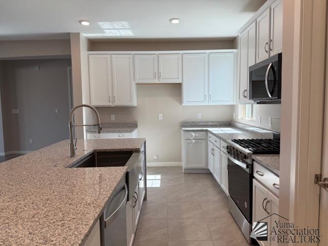 12373 S Drucilla Ln, Yuma, AZ 85367 - kitchen featuring stainless steel appliances, white cabinetry, light stone counters, light tile patterned floors, and recessed lighting