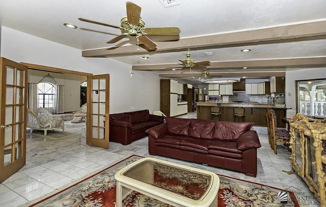 living room with ceiling fan, french doors, and beamed ceiling