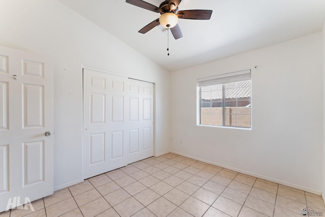 unfurnished bedroom featuring a closet, baseboards, ceiling fan, and vaulted ceiling