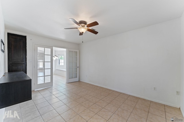 spare room with a ceiling fan, baseboards, and light tile patterned flooring