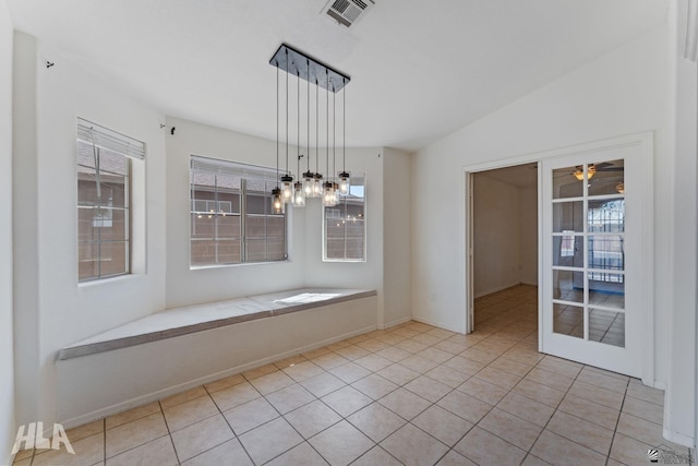 unfurnished dining area with visible vents, ceiling fan with notable chandelier, plenty of natural light, and tile patterned flooring