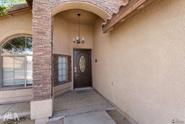 view of exterior entry with stucco siding and stone siding