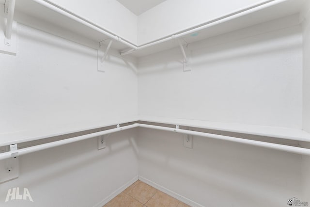 walk in closet with light tile patterned floors
