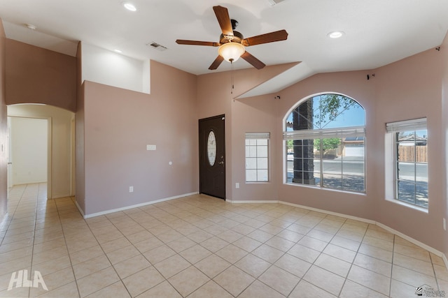 interior space with visible vents, light tile patterned flooring, baseboards, ceiling fan, and high vaulted ceiling