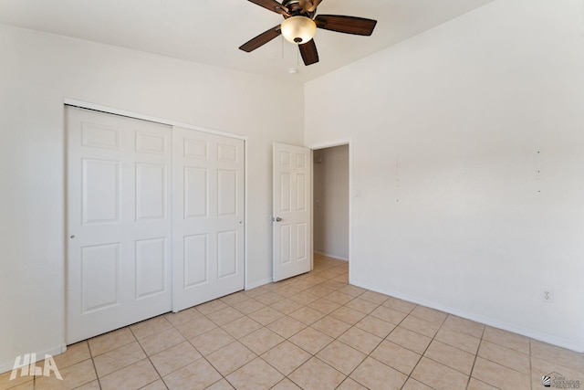 unfurnished bedroom featuring a ceiling fan, baseboards, light tile patterned floors, and a closet