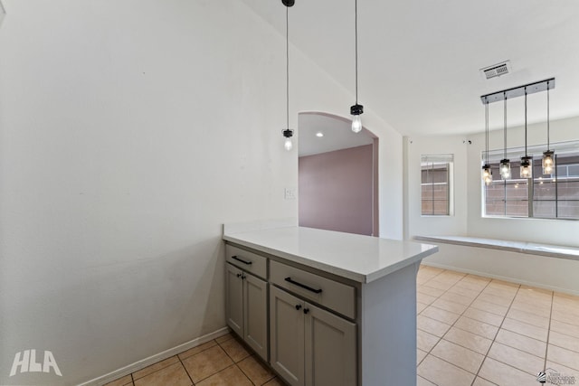 kitchen with visible vents, a peninsula, light tile patterned flooring, light countertops, and gray cabinetry