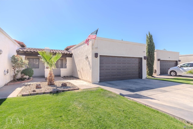 view of front of house with a front lawn, a tile roof, a garage, stucco siding, and driveway