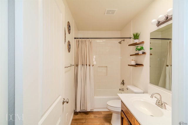 full bath with shower / tub combo with curtain, vanity, toilet, wood finished floors, and visible vents