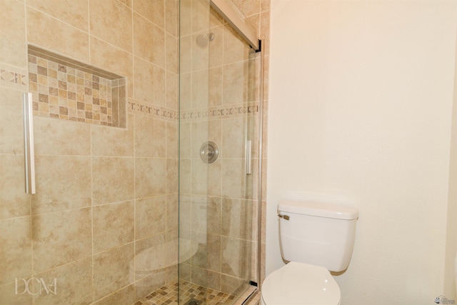 full bathroom featuring a stall shower and toilet