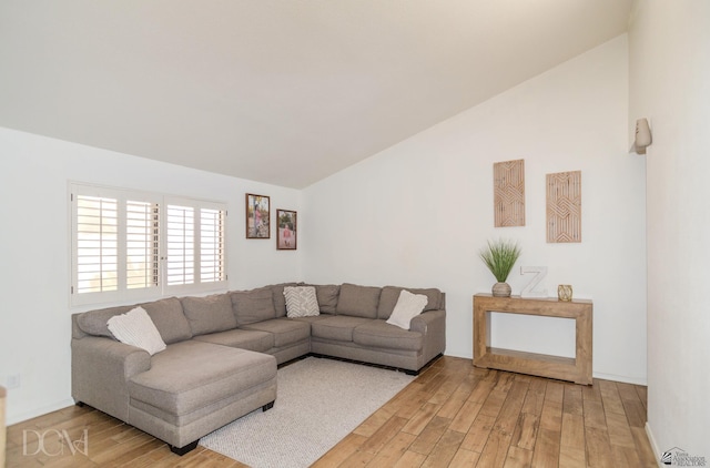 living room featuring light wood-style floors and vaulted ceiling