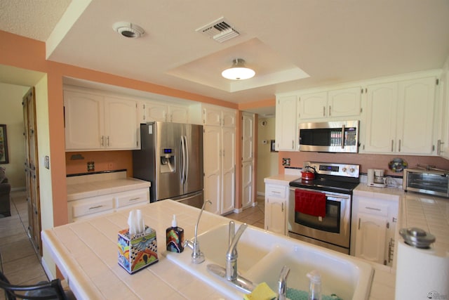 12459 E Del Rey Dr, Yuma, AZ 85367 - kitchen featuring tile countertops, visible vents, a toaster, stainless steel appliances, and white cabinetry