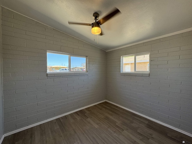 2641 S Las Palmas Vista Ave, Yuma, AZ 85364 - empty room with baseboards, lofted ceiling, dark wood finished floors, ceiling fan, and brick wall