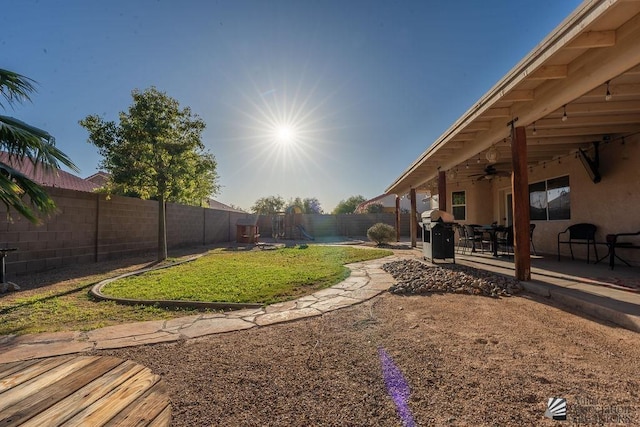 view of yard with ceiling fan, a fenced backyard, and a patio area
