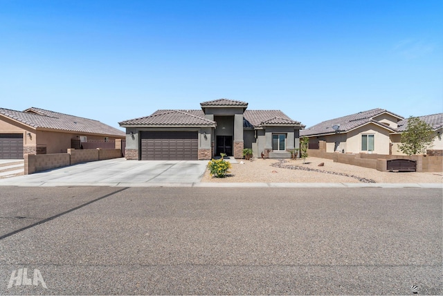 12590 E 48th Dr, Yuma, AZ 85367 - view of front of house featuring stucco siding, a garage, a tile roof, driveway, and stone siding