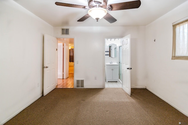 500 S 7th Ave, Yuma, AZ 85364 - unfurnished bedroom featuring light colored carpet, ensuite bath, and ceiling fan