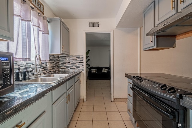 kitchen featuring black / electric stove, visible vents, gray cabinetry, a sink, and under cabinet range hood