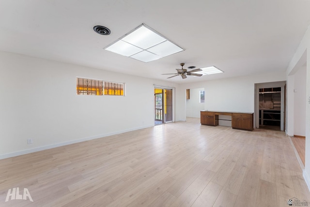 324 S 19th Ave, Yuma, AZ 85364 - unfurnished living room with light wood-type flooring, baseboards, a skylight, and ceiling fan