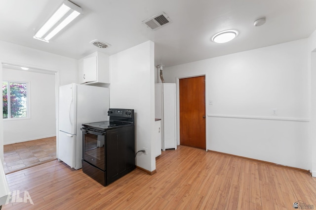 324 S 19th Ave, Yuma, AZ 85364 - kitchen featuring freestanding refrigerator, visible vents, black electric range, white cabinets, and light wood-type flooring