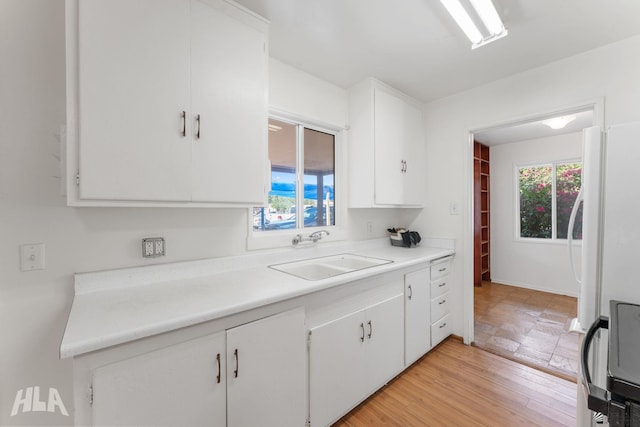 324 S 19th Ave, Yuma, AZ 85364 - kitchen with light countertops, plenty of natural light, white cabinets, and a sink